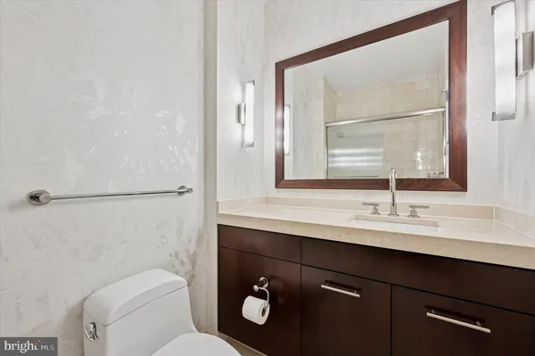 a bathroom with a toilet a sink a mirror and a window