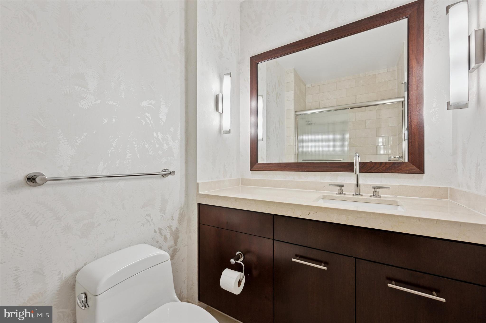 1414 South Penn Square, Unit 26CDE Philadelphia, PA 19102 - Photo 15 of 53 a bathroom with a toilet a sink a mirror and a window