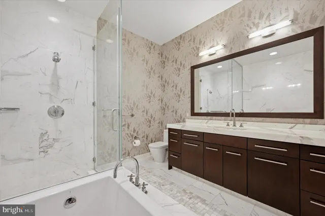 a spacious bathroom with a bathtub sink mirror and shower