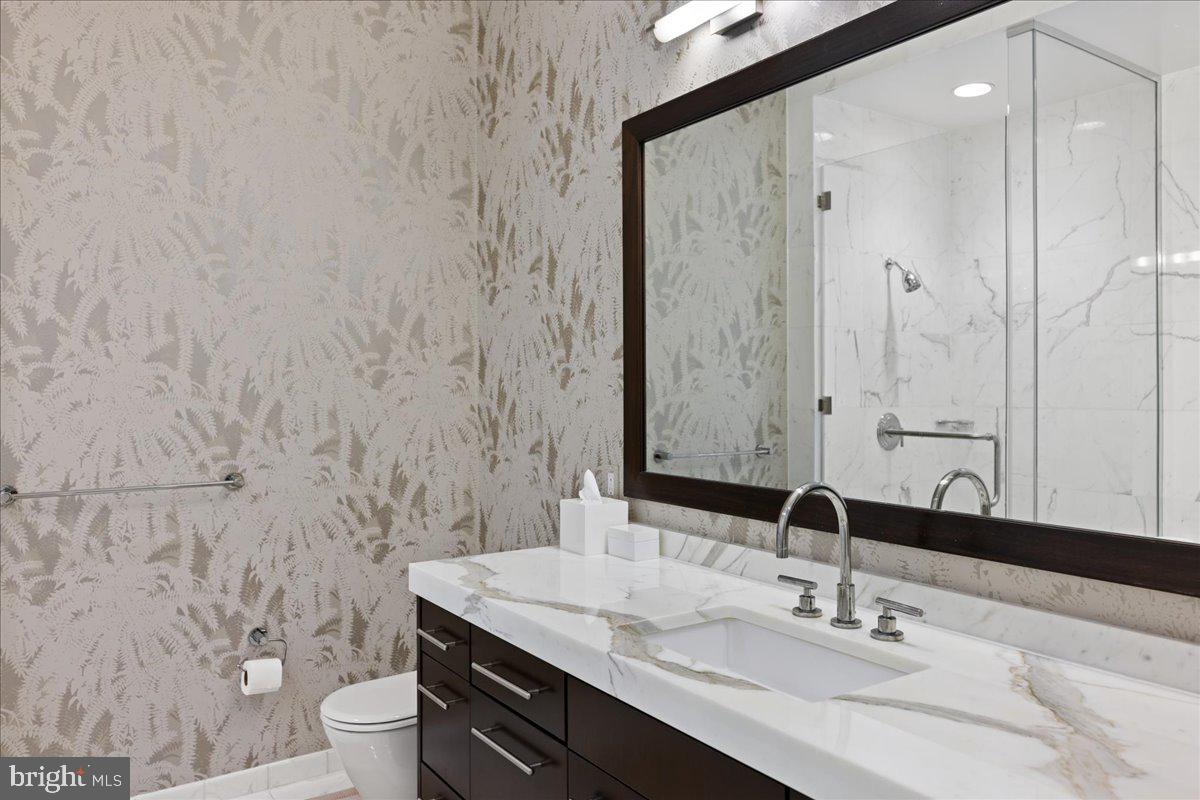 1414 South Penn Square, Unit 26CDE Philadelphia, PA 19102 - Photo 22 of 53 a bathroom with a granite countertop sink a toilet and a mirror