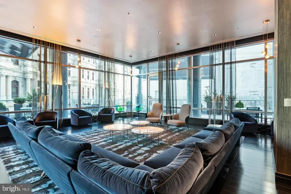 a living room with furniture and large windows
