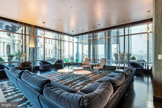 a living room with furniture and large windows