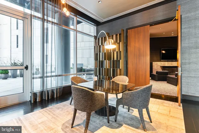 a dining room with furniture and large windows