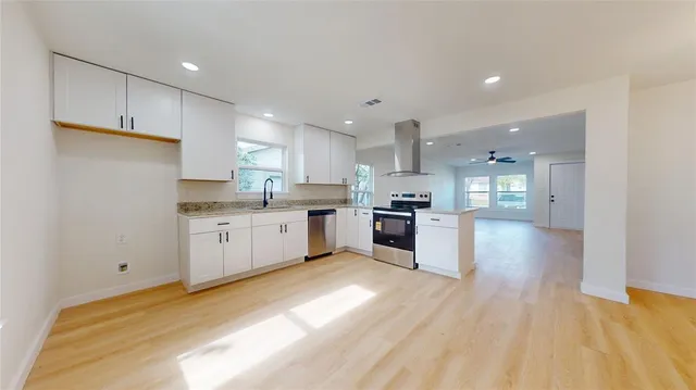 a large kitchen with a lot of counter space and stainless steel appliances
