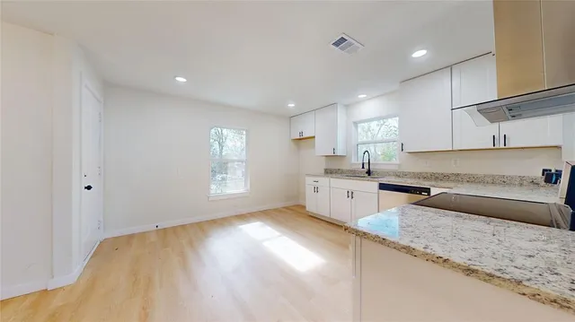 a kitchen with a refrigerator sink and cabinets