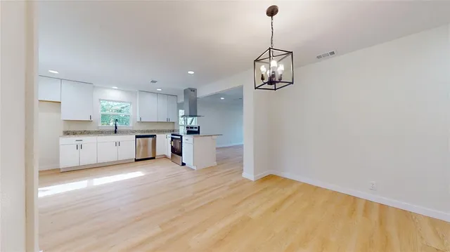 a view of a kitchen with a sink wooden cabinets and stainless steel appliances
