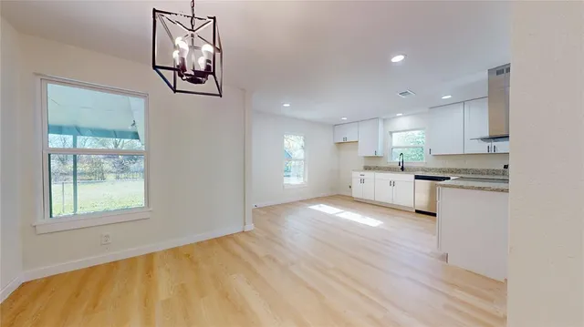 a view of a kitchen with wooden floor and windows