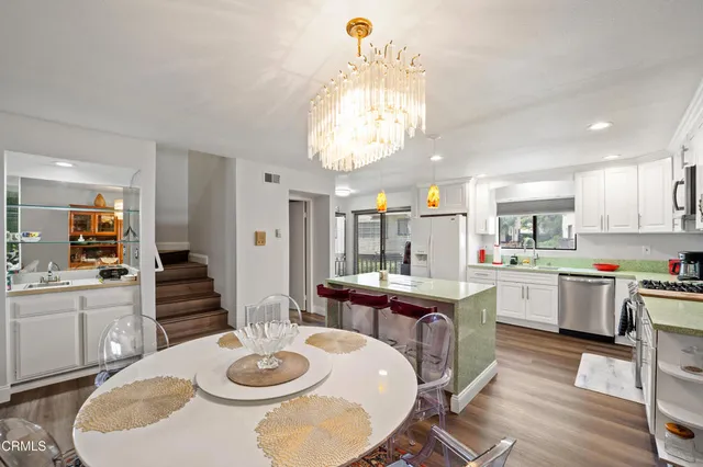 a open dining room with kitchen island furniture a chandelier and kitchen view