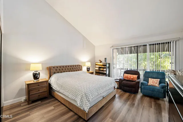 a bedroom with a bed and a couch next to a window