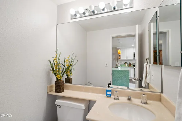 a bathroom with a sink a toilet and a mirror