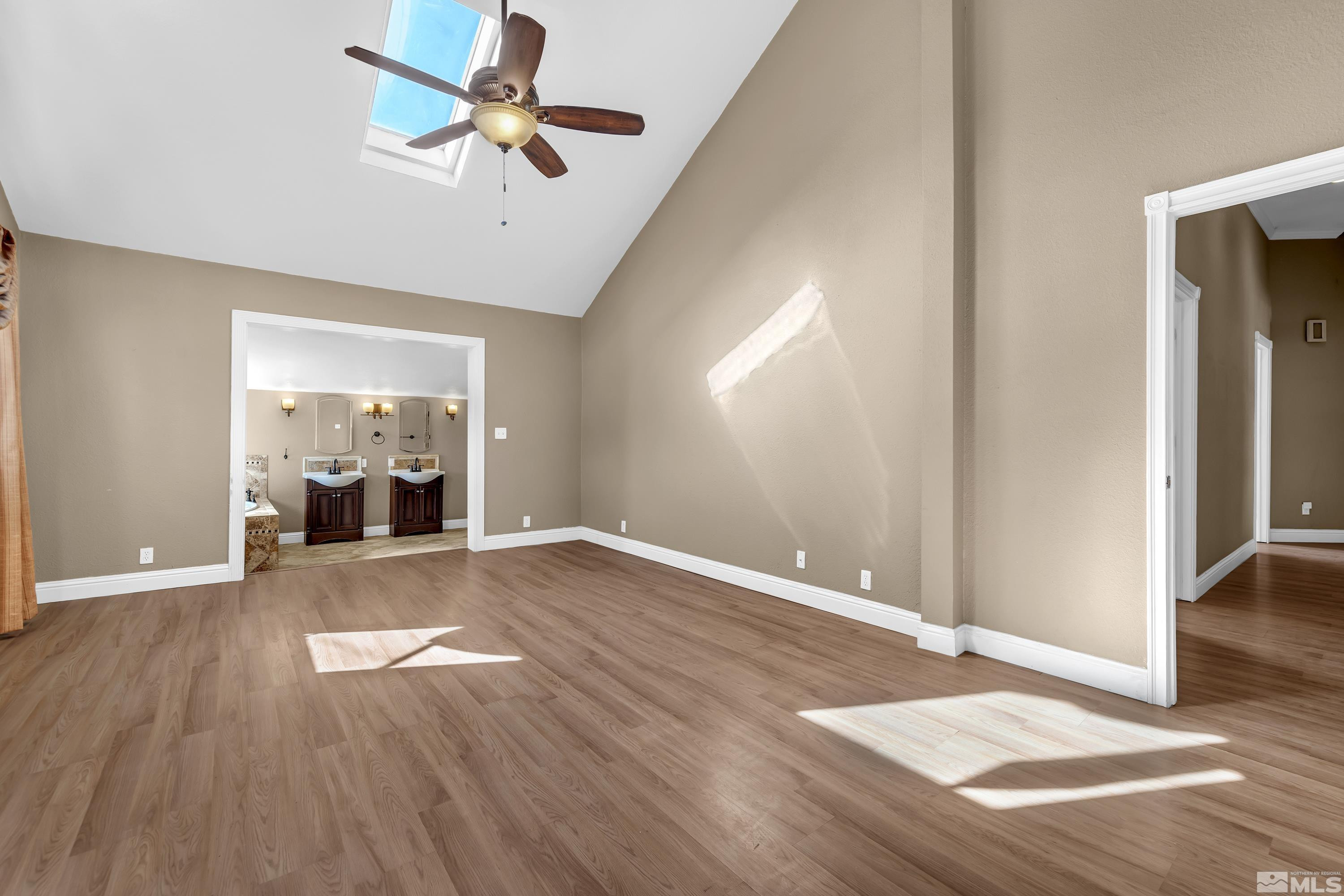 4600 Pasture View Road Reno, NV 89510 - Photo 26 of 40 an empty room with wooden floor chandelier fan and windows