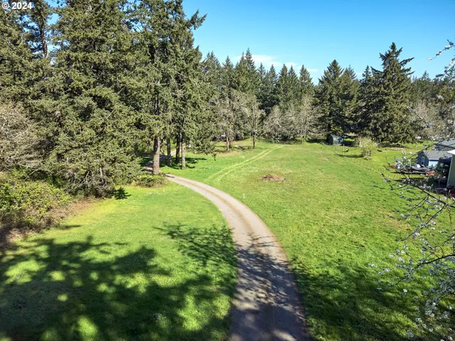 a large yard with lots of green space and trees around