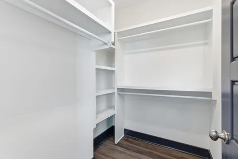 a view of walk in closet with empty racks