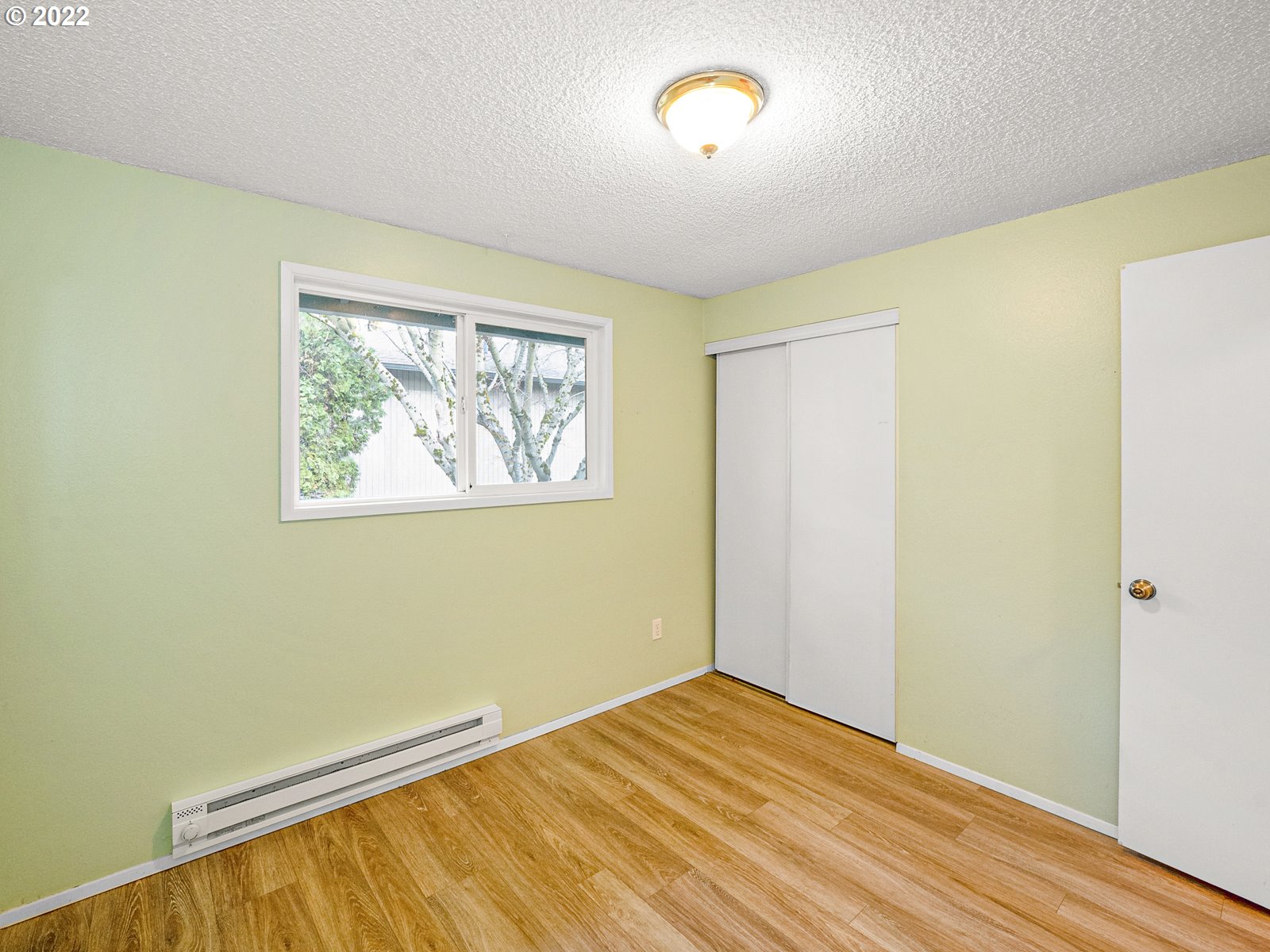 8810 Southeast Rural Street Portland, OR 97266 - Photo 13 of 32 an empty room with wooden floor and windows