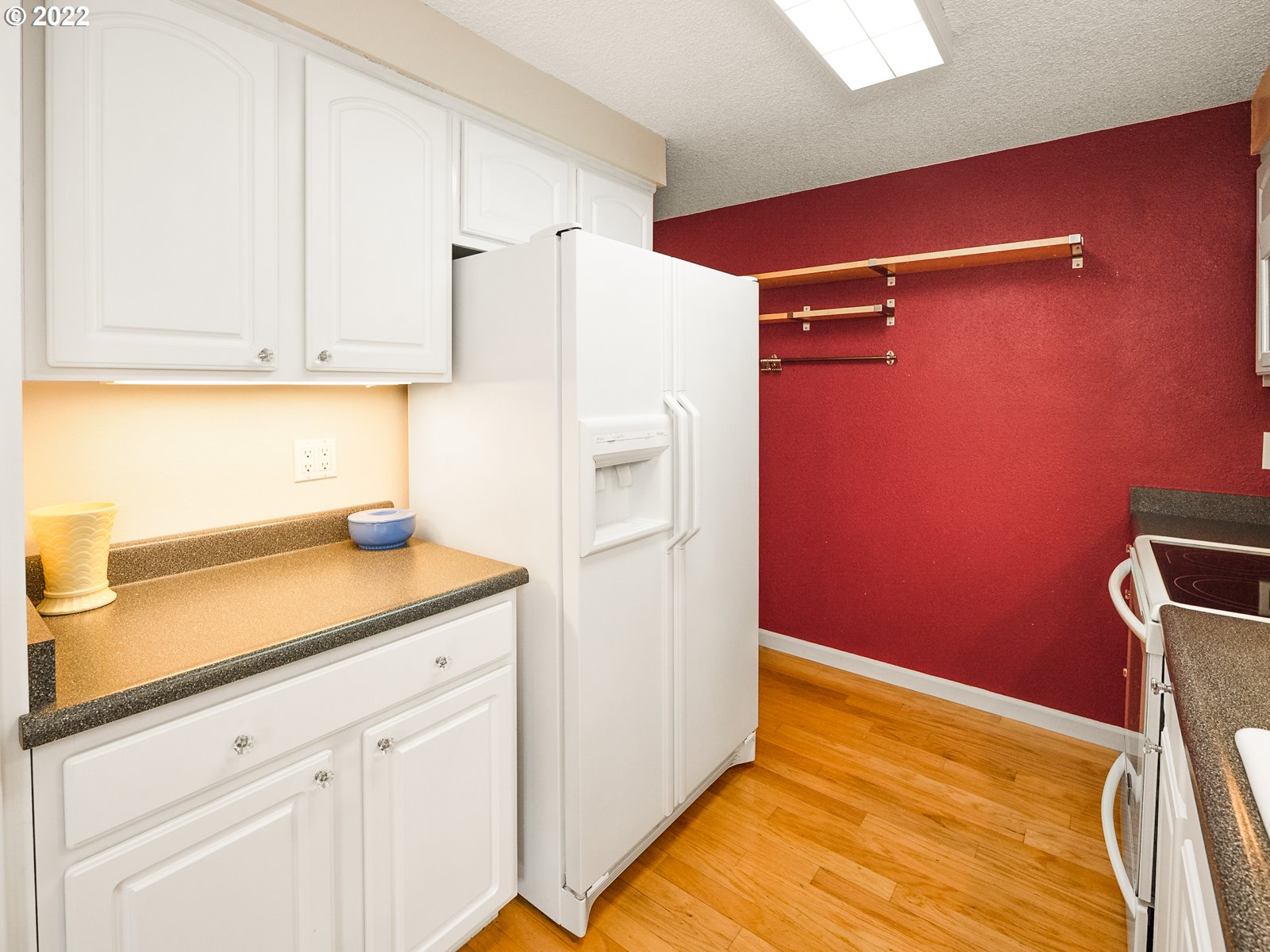 8810 Southeast Rural Street Portland, OR 97266 - Photo 8 of 32 a kitchen with a refrigerator and cabinets
