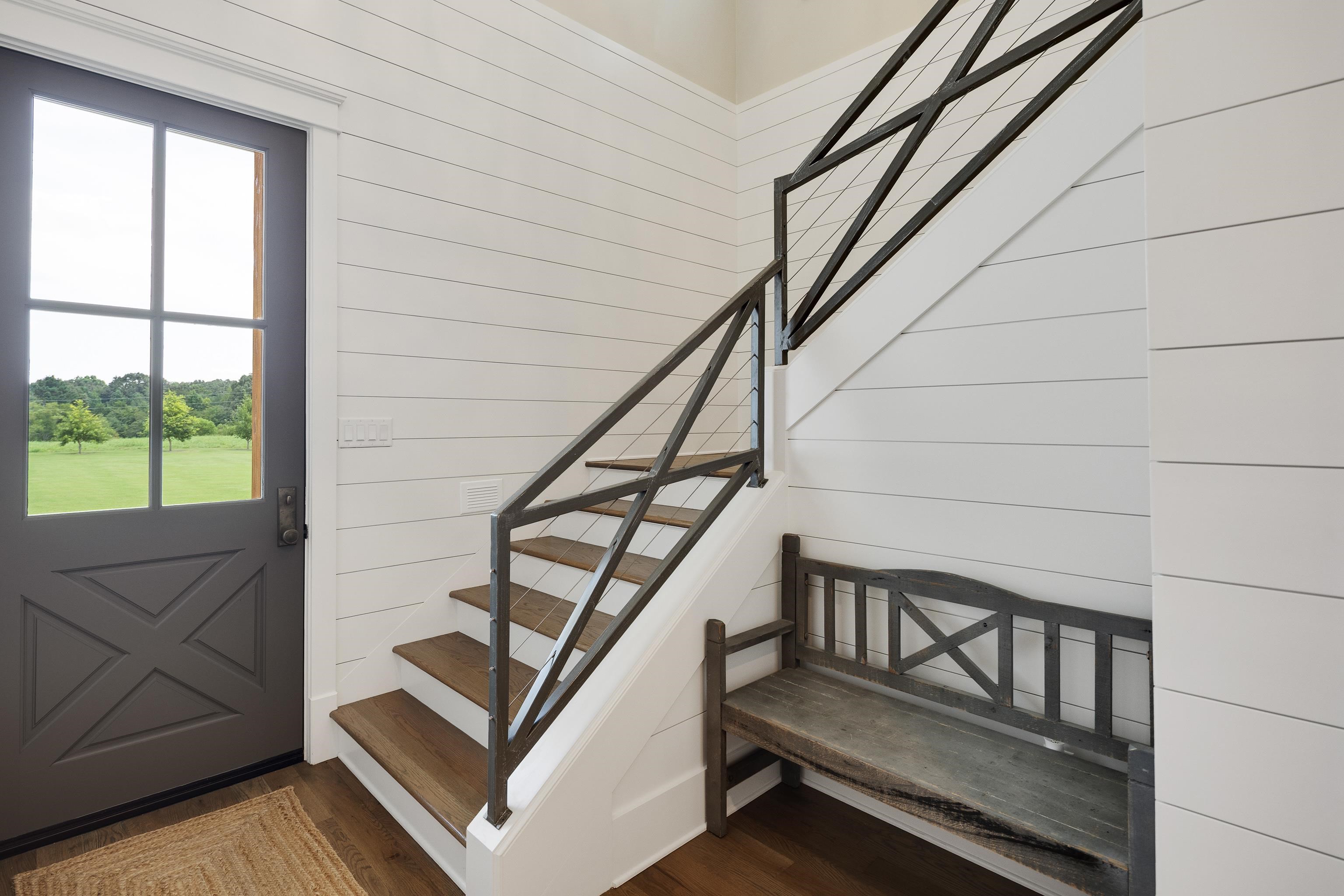 805 Shady Grove Road Williston, TN 38076 - Photo 26 of 40 Shiplap wall paneling, wood-finish flooring, staircase with cable railing, paneled door with window, and built-in bench