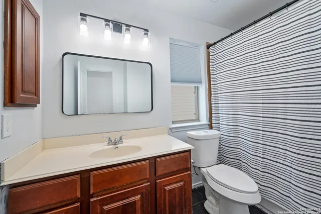 a bathroom with a toilet a sink and mirror