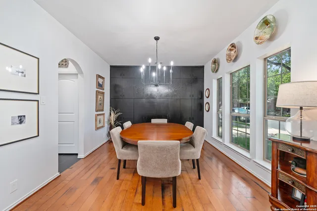 a dining room with furniture a chandelier and wooden floor