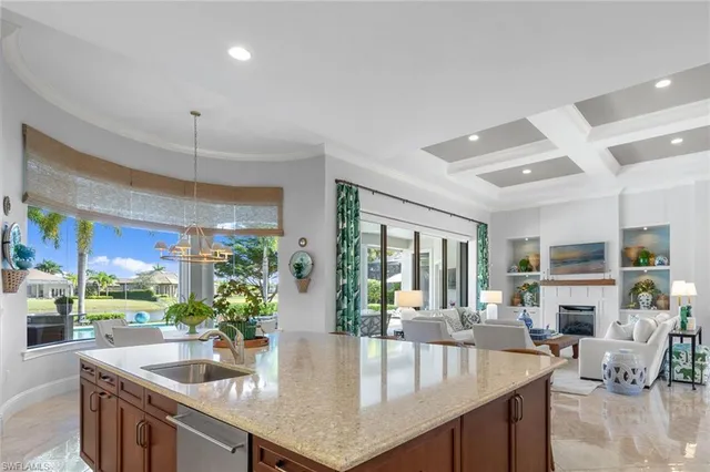 a kitchen with granite countertop a stove dining table chairs and a large window with garden view