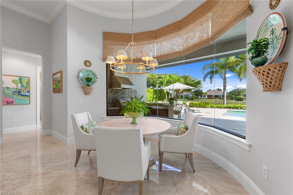 4170 Cortland Way Naples, FL 34119 - Photo 13 of 41 Dining room with crown molding, light marble finish flooring, and a chandelier