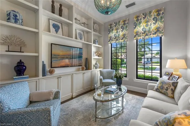 a living room with furniture a flat screen tv and a large window
