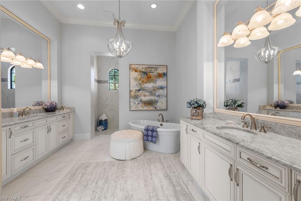 4170 Cortland Way Naples, FL 34119 - Photo 18 of 41 Full bathroom featuring a chandelier, two vanities, a soaking tub, ornamental molding, and a marble finish shower
