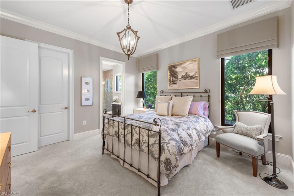 4170 Cortland Way Naples, FL 34119 - Photo 20 of 41 Bedroom with multiple windows, crown molding, carpet, ensuite bath, and a chandelier