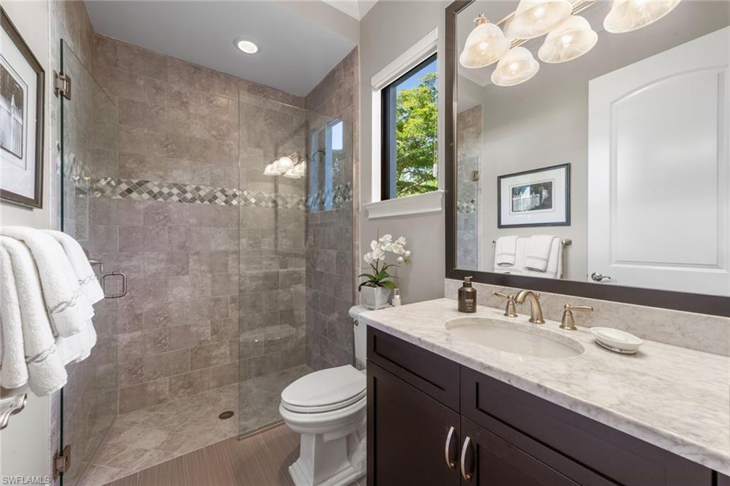 4170 Cortland Way Naples, FL 34119 - Photo 21 of 41 Bathroom with vanity, a shower stall, and a chandelier