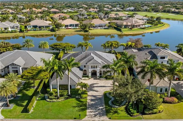 an aerial view of residential houses with outdoor space and lake view
