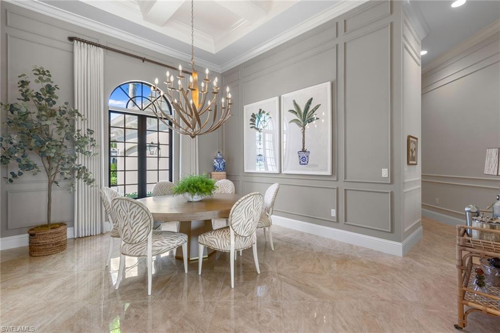4170 Cortland Way Naples, FL 34119 - Photo 6 of 41 Dining room featuring a decorative wall, light marble finish floors, crown molding, plenty of natural light, and coffered ceiling