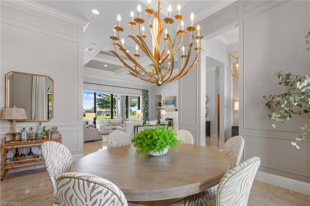 4170 Cortland Way Naples, FL 34119 - Photo 7 of 41 Dining area with a decorative wall, crown molding, a chandelier, coffered ceiling, and wainscoting