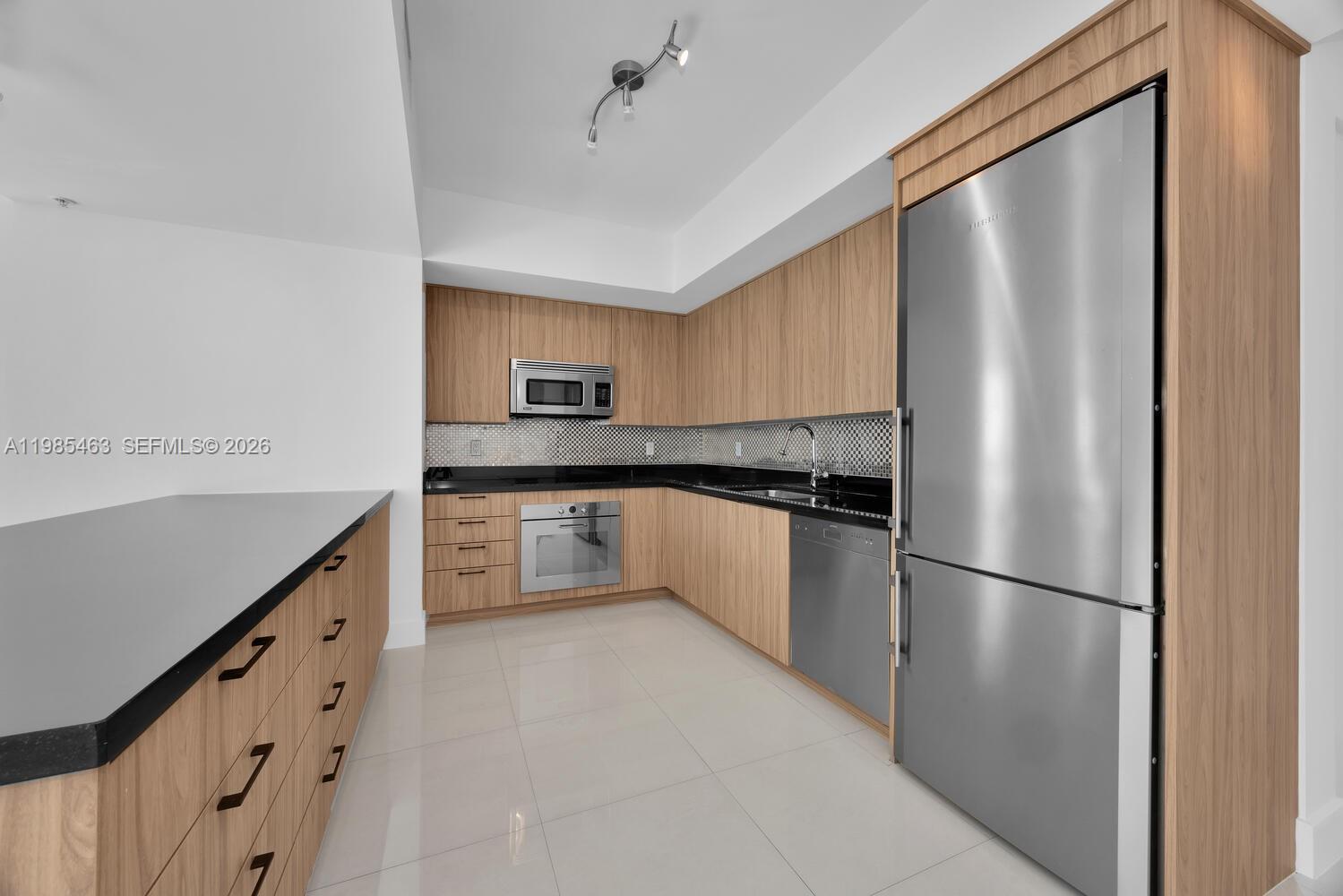 92 Southwest 3rd Street, Unit 3904 Miami, FL 33130 - Photo 7 of 30 a kitchen with granite countertop a refrigerator and a sink