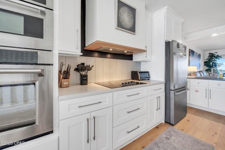 23223 Front Beach Road, Unit A1 PH10 Panama City Beach, FL 32413 - Photo 13 of 32 a kitchen with white cabinets and appliances