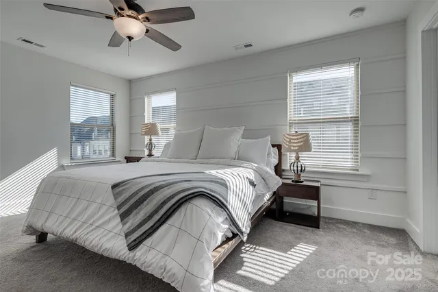 a bedroom with a large bed and a chandelier