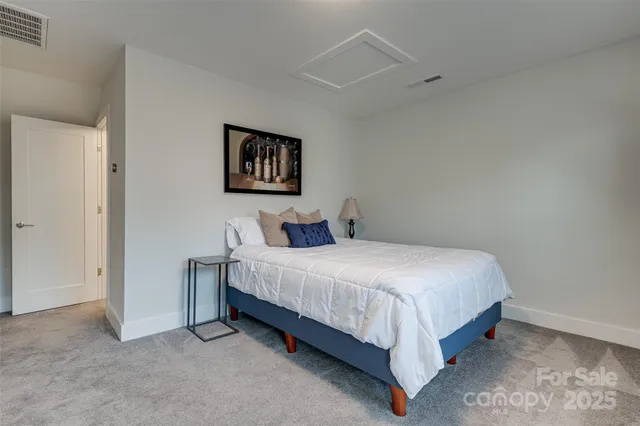 a bedroom with a bed a tv and wooden floor