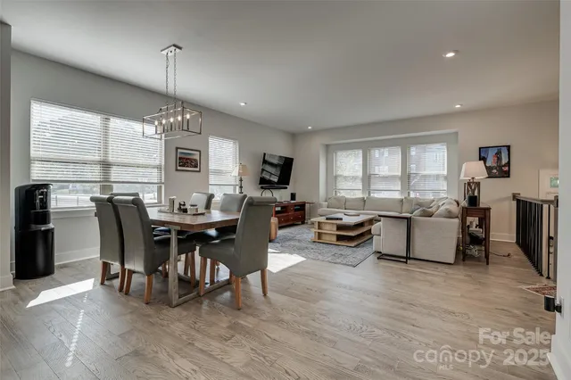 a kitchen with stainless steel appliances kitchen island a table chairs sink refrigerator and microwave