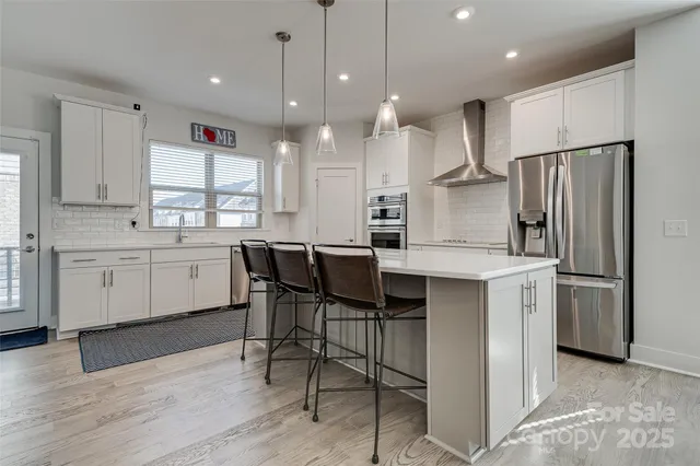 a large kitchen with cabinets wooden floor and stainless steel appliances