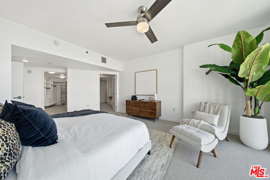 13650 Marina Pointe Drive, Unit 1603 Marina del Rey, CA 90292 - Photo 31 of 75 a spacious bedroom with a bed a couch and a potted plant
