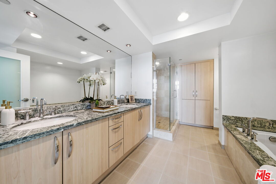 13650 Marina Pointe Drive, Unit 1603 Marina del Rey, CA 90292 - Photo 34 of 75 a large bathroom with a large mirror vanity and shower