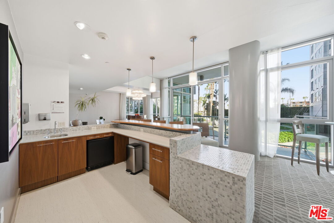 13650 Marina Pointe Drive, Unit 1603 Marina del Rey, CA 90292 - Photo 65 of 75 a large kitchen with kitchen island a sink a stove a dining table and chairs