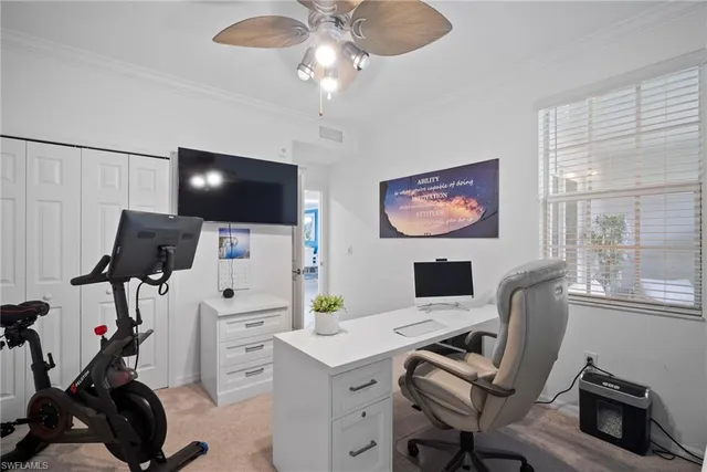 a view of a workspace with furniture and a window