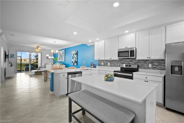 a kitchen with a sink a counter top space stainless steel appliances and cabinets