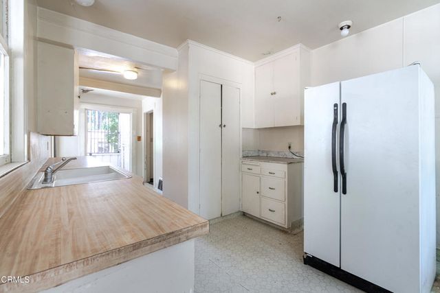 a kitchen with white cabinets and refrigerator