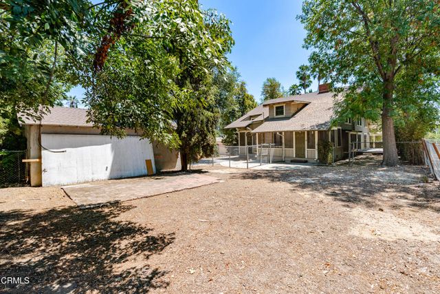 a view of a house with a large window and wooden fence