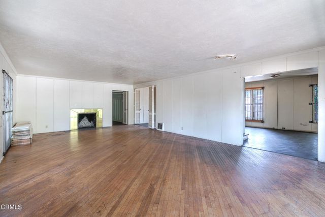 a view of a livingroom with wooden floor and a window
