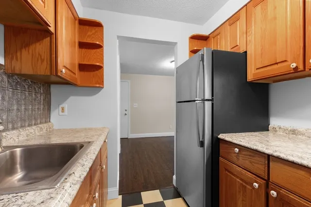 a kitchen with granite countertop stainless steel appliances a refrigerator and a sink