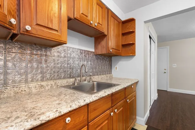 a kitchen with stainless steel appliances granite countertop a sink a stove and cabinets