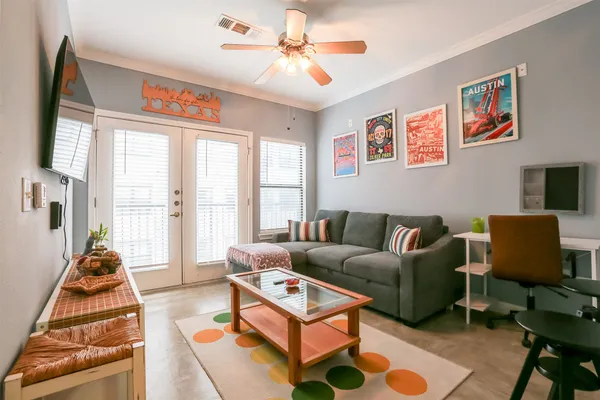 a living room with furniture a flat screen tv and a large window