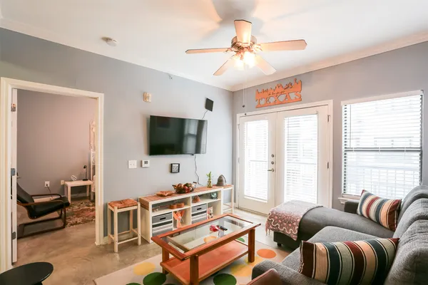 a living room with furniture a large window and a flat screen tv