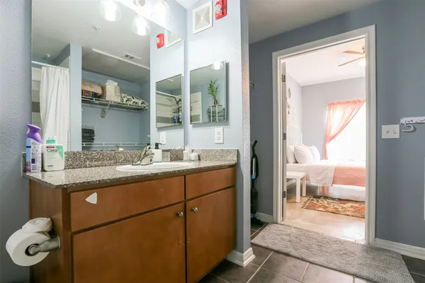a bathroom with a granite countertop sink a toilet and a mirror